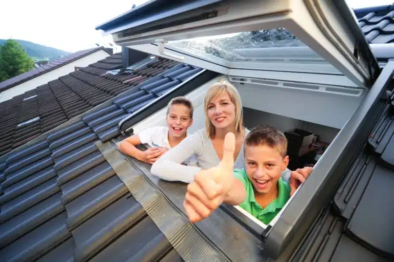 Famille à la fenêtre de toit de combles aménagés